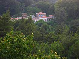 Der Ort Nikoloudes auf Samos mit wenigen Häusern in grüner Hügellandschaft.