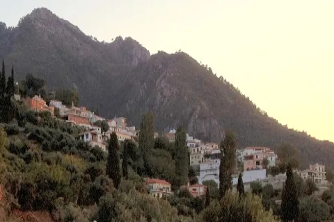 Vista panoramica del villaggio di Ambelos a Samo con case tradizionali e vegetazione.