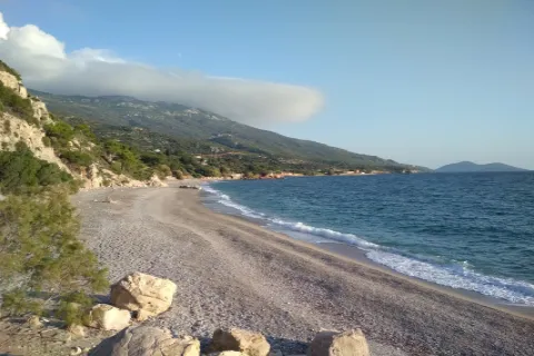 Spiaggia Perri a Samo con mare cristallino e vista sul villaggio vicino.