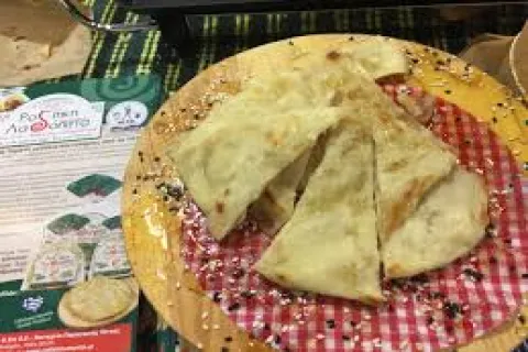 Παραδοσιακή λαδόπιτα από τη Σάμο σε ξύλινη επιφάνεια, κομμένη σε τρίγωνα κομμάτια με χρυσαφένιο χρώμα