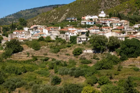 Il villaggio Mesogeios a Samo con case in pietra e vista sul mare e le colline.