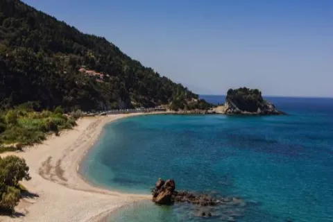 Der Strand Potami auf Samos mit Kieseln und Wasserfällen im Hintergrund.