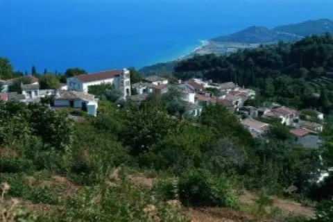 Άποψη των Σταυρινήδων Σάμου από ψηλά, με πέτρινα σπίτια και φόντο τη θάλασσα.