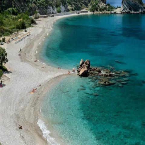 Παραλία Ποτάμι στη Σάμο με μεγάλα βότσαλα, άγρια φύση και φόντο το Καρλόβασι