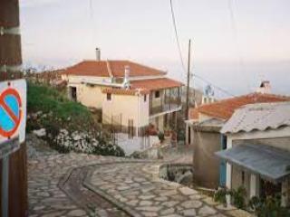 Vicolo in pietra con case tradizionali a Kosmadaioi, Samo, con vista sul mare.