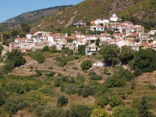 Il villaggio Mesogeios a Samo con case in pietra e vista sul mare e le colline.