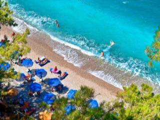 Spiaggia Tsamadou a Samo con acqua turchese, ciottoli e paesaggio verde intorno