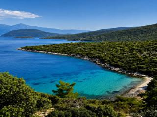 Het afgelegen strand Mikri Lakka in het oosten van Samos met fijne kiezels, pijnbomen en helder turquoise water